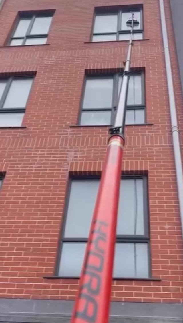 Water-fed pole reaching apartment windows